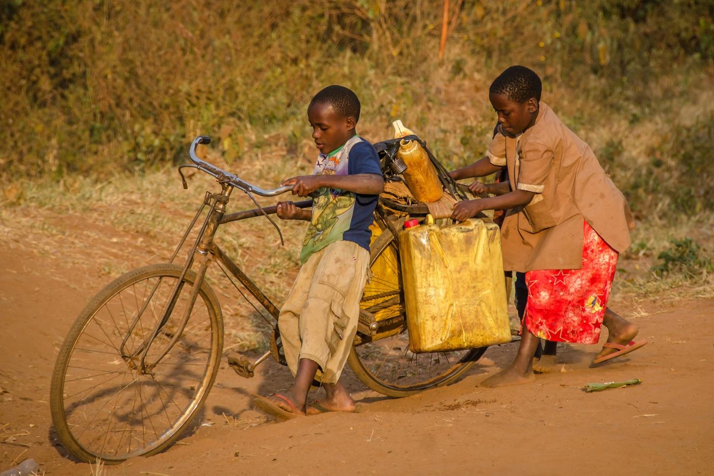 A man carrying water containers on a bicycle